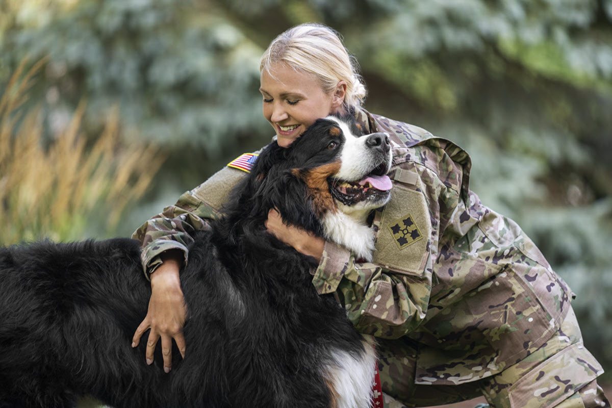 A female veteran hugging her dog.